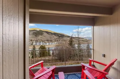 two red chairs on a balcony with a view at The Lodge at Lake Dillon 111 in Dillon