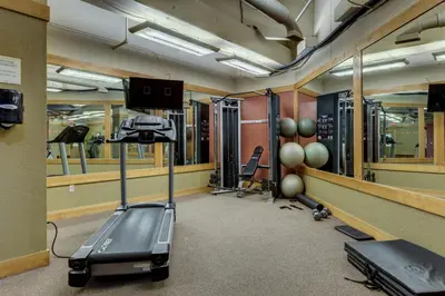 a room with a gym with a treadmill and weights at Silver Mill by Summit County Mountain Retreats in Keystone