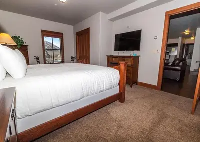 a bedroom with a bed and a flat screen tv at Oro Grande by Summit County Mountain Retreats in Keystone