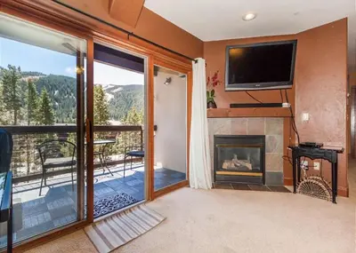a living room with a fireplace and a flat screen tv at Oro Grande by Summit County Mountain Retreats in Keystone