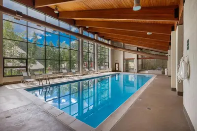 a swimming pool in a house with windows at Pines by Summit County Mountain Retreats in Keystone