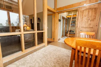 a dining room with a table and some windows at Pines by Summit County Mountain Retreats in Keystone