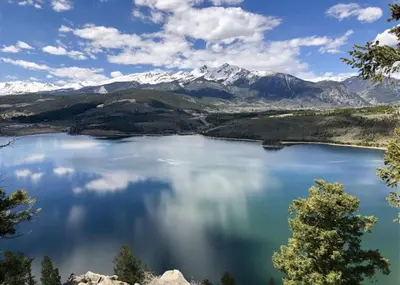 a view of a lake with snow capped mountains at Pines by Summit County Mountain Retreats in Keystone