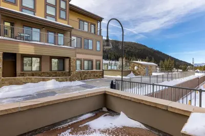a house with a balcony with snow in front of it at Slopeside by Summit County Mountain Retreats in Keystone