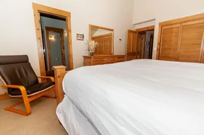 a bedroom with a large bed and a chair at Ski Tip by Summit County Mountain Retreats in Keystone
