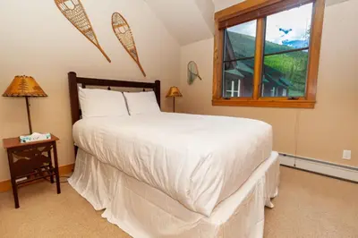a bedroom with a large bed and a window at Ski Tip by Summit County Mountain Retreats in Keystone