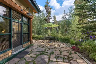 a patio with a table and an umbrella at Ski Tip by Summit County Mountain Retreats in Keystone