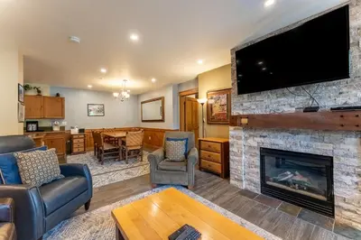 a living room with a fireplace and a flat screen tv at Springs by Summit County Mountain Retreats in Keystone