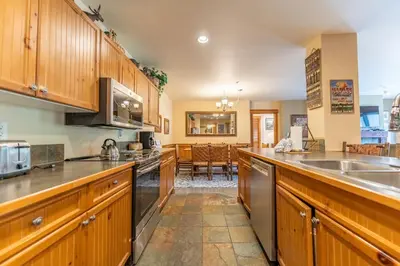 a kitchen with wooden cabinets and a counter top at Springs by Summit County Mountain Retreats in Keystone