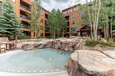 a large swimming pool in a yard with a building at Springs by Summit County Mountain Retreats in Keystone
