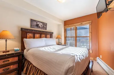 a bedroom with a large bed and a window at Tenderfoot Lodge by Summit County Mountain Retreats in Keystone