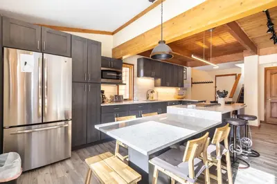 a kitchen with a stainless steel refrigerator and wooden cabinets at Tennis Townhome 1337 : 2 in Keystone