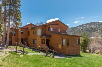 a large wooden house in a field of grass at Tennis Townhome 1337 : 2 in Keystone