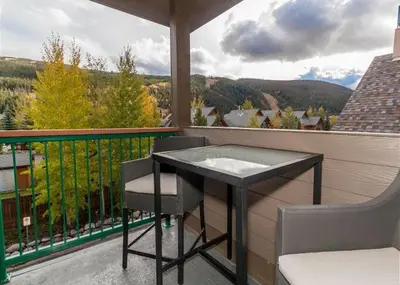 a black table and chairs on a balcony with a view at Gateway by Summit County Mountain Retreats in Keystone