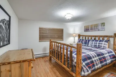 a bedroom with a bed and a wooden crib at Condo with Pool Access 2 Mi to Winter Park Resort! in Winter Park
