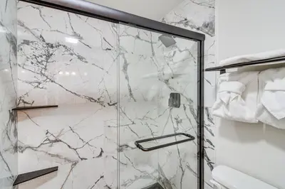 a shower with marble walls and a glass door at Condo with Pool Access 2 Mi to Winter Park Resort! in Winter Park