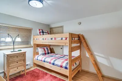 a bedroom with a bunk bed and a desk at Condo with Pool Access 2 Mi to Winter Park Resort! in Winter Park