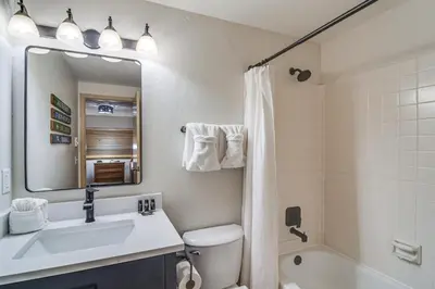a bathroom with a sink and a toilet and a mirror at Condo with Pool Access 2 Mi to Winter Park Resort! in Winter Park