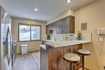 a kitchen with wooden cabinets and a counter with stools at 8 Mi to Copper Mtn Sleek Frisco Townhome with Views in Frisco