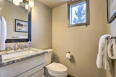 a bathroom with a toilet and a sink and a window at 8 Mi to Copper Mtn Sleek Frisco Townhome with Views in Frisco