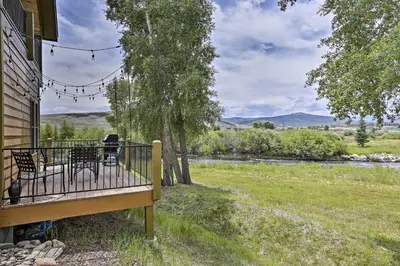 a porch with chairs and a view of a river at Fish, Hike and Ski Riverfront Granby Cabin! in Granby