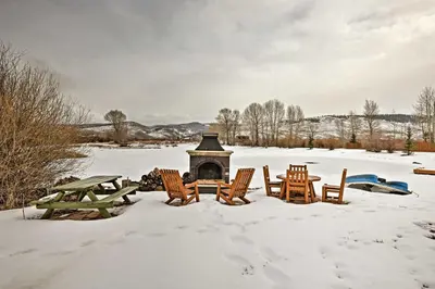 a group of chairs and a fireplace in the snow at Fish, Hike and Ski Riverfront Granby Cabin! in Granby