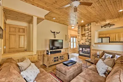 a living room with a couch and a tv at Fish, Hike and Ski Riverfront Granby Cabin! in Granby