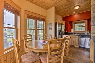 a kitchen and dining room with a table and chairs at Fish, Hike and Ski Riverfront Granby Cabin! in Granby