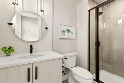 a bathroom with a toilet and a sink and a mirror at Old Town Modern New Build - Rooftop Spa with Mtn Views! in Fort Collins