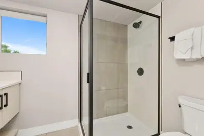 a bathroom with a shower with a glass door at Old Town Modern New Build - Rooftop Spa with Mtn Views! in Fort Collins