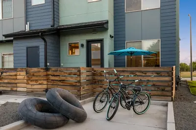 two bikes parked in front of a house with an umbrella at Old Town Modern New Build - Rooftop Spa with Mtn Views! in Fort Collins