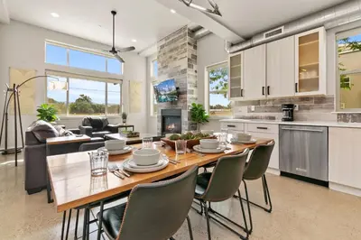 a kitchen and dining room with a wooden table and chairs at Old Town Modern New Build - Rooftop Spa with Mtn Views! in Fort Collins