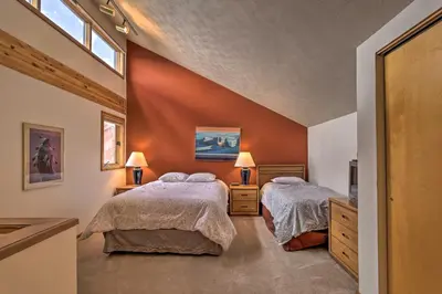 two beds in a bedroom with orange walls at Resort Perks and Trail Access Silverthorne Condo! in Silverthorne