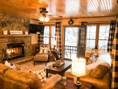 a living room with leather furniture and a fireplace at Riverfront Mountain Cottage Retreat in Estes Park