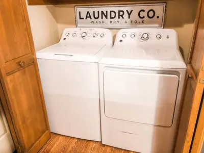 a laundry room with a white washer and dryer at Riverfront Mountain Cottage Retreat in Estes Park