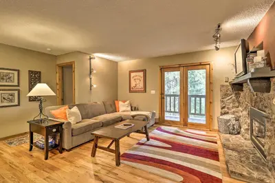 a living room with a couch and a fireplace at Cozy Condo on Vasquez Creek with Free Shuttle Access in Winter Park