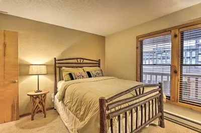 a bedroom with a wooden bed and a window at Cozy Condo on Vasquez Creek with Free Shuttle Access in Winter Park