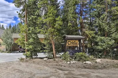 a sign for a cafe in front of trees at Cozy Condo on Vasquez Creek with Free Shuttle Access in Winter Park