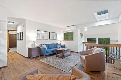 a living room with a blue couch and a table at Horsetooth Stoop Trails, Lake Access and Mountain Views in Fort Collins