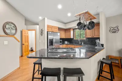 a kitchen with a island with black counter stools at Cutty Sark Court #1 3BR Mountain Views townhouse in Silverthorne