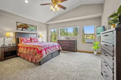 a bedroom with a bed and a dresser and windows at Cutty Sark Court #1 3BR Mountain Views townhouse in Silverthorne