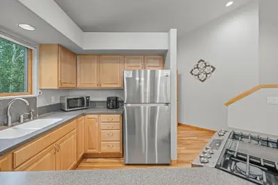 a kitchen with a stainless steel refrigerator and wooden cabinets at Cutty Sark Court #2 3BR Mountain Views townhouse in Silverthorne