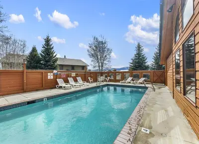 a swimming pool with chairs and a fence at 75 Corinthian 3Br 3Ba Spacious Layout, Private Garage townhouse in Dillon