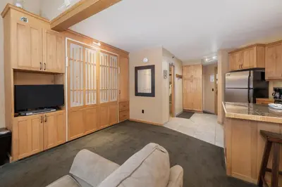 a large kitchen with wooden cabinets and a tv at Iron Horse C5083 condo in Winter Park