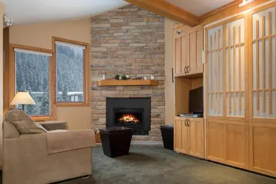 a living room with a fireplace and a chair at Iron Horse C5083 condo in Winter Park