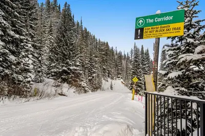 a sign on a snow covered road with trees at Iron Horse Studio Retreat in Winter Park
