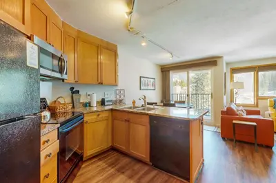 a kitchen with wooden cabinets and a counter top at Iron Horse Studio Retreat in Winter Park