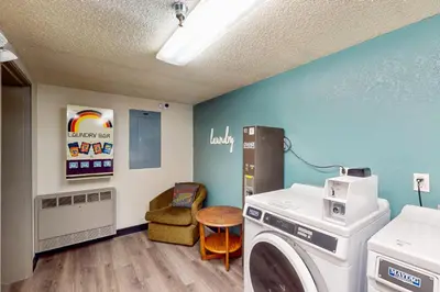 a laundry room with a washing machine and a chair at Iron Horse Studio Retreat in Winter Park