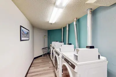 a laundry room with a row of white washing machines at Iron Horse Studio Retreat in Winter Park
