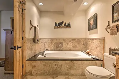 a bathroom with a tub and a toilet at Deck, Bar and Mtn Views Grand Granby Retreat! in Granby